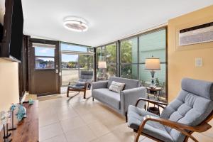 a living room with couches and chairs and windows at Key Largo Tiny House, Marina, Beach, and Pool Access in Key Largo
