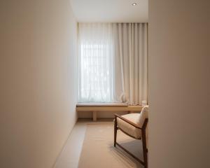 a white room with a chair and a window at Hostal Serea in Denia +17 photos