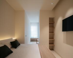 a bedroom with a bed and a tv on a wall at Hostal Serea in Denia