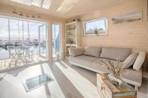 ein Wohnzimmer mit einem Sofa und einem Tisch in der Unterkunft Ostsee Hausboot Swantje in Heiligenhafen