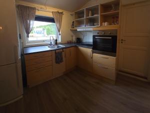 a kitchen with wooden cabinets and a sink and a window at Airport Central Apartment in Alta +9 photos