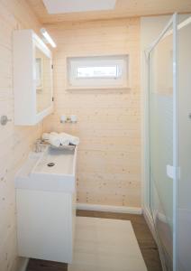 een badkamer met een witte wastafel en een douche bij Ostsee Hausboot Swantje in Heiligenhafen