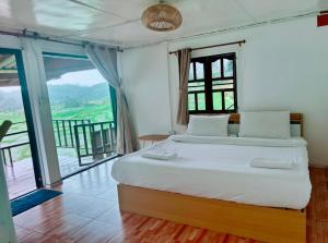a bedroom with a large bed with a balcony at Mae Klang Luang Villa แม่กลางหลวงวิลล่า in Ban Sop Mae Klang +10 photos