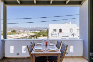 a table on a balcony with a view of a city at Casa Di Flora in Agios Prokopios