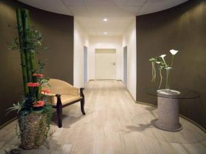 a hallway with a chair and a table and flowers at Boutique Hotel Azul in Möhnesee