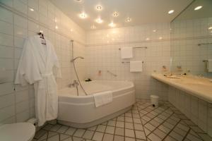 a white bathroom with a tub and a toilet at Boutique Hotel Azul in Möhnesee