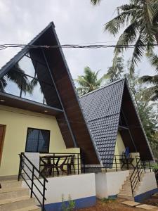 a house with a gambrel roof with stairs leading to it at Aastha Gokarna in Gokarn +5 photos