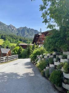 a road with a retaining wall and a house at Ferienwohnung Sonnheim Alpbachtal Card inklusive in Alpbach