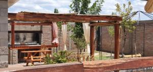a wooden pergola with a bench in a backyard at Nelumbo Petit Chalet in San Rafael