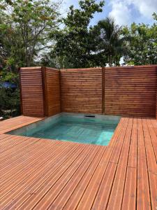a swimming pool on a deck with a wooden fence at La Baie des Villas in Deshaies