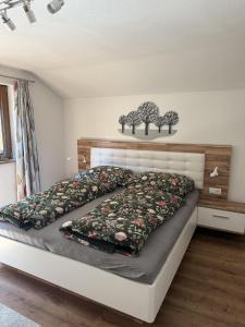 a bedroom with a bed with two trees on the wall at Ferienwohnung Sonnheim Alpbachtal Card inklusive in Alpbach