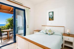 a bedroom with a bed and a balcony at Villa Seashell in Pefki