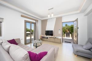 a living room with a couch and a tv at Villa Vatia 1 in Tragaki