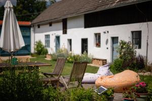 a patio with a table and chairs and an umbrella at Statek u Benešů in Ponědraž