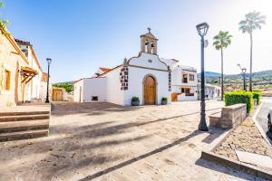 a church in a street with palm trees and a street light at Casa Susa in Adeje