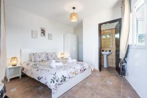 a white bedroom with a bed and a mirror at Casa Susa in Adeje