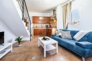 a living room with a blue couch and a table at Casa Susa in Adeje