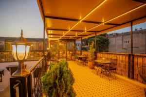 ein Balkon mit Tischen, Stühlen und einer Lampe in der Unterkunft RIAD HIKAYA - Born of History in Fès