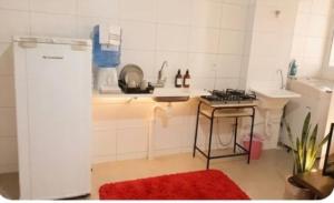 a small kitchen with a sink and a stove at Apartamento Compacto Localização Privilegiada in Uberaba