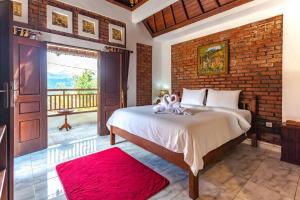 a bedroom with a bed and a brick wall at The Garuda Villa and Restaurant in Bedugul +40 photos