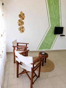 a room with two chairs and a table and a television at Studio Poivre - Séjour tropical à Nosy Be in Madirokely