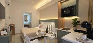 a room with a bed and a table and a kitchen at Salyn Apartments - The Heart of Tropea - Your Perfect Stay in Tropea