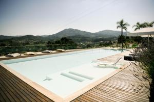 a swimming pool with a chair and a table at 3Encostas in Cabeceiras de Basto