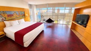 a bedroom with a bed and a flat screen tv at Hotel Pascana Plaza in Santa Cruz de la Sierra