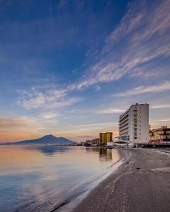 a view of a beach with a building and the water at the sea beyond in Castellammare di Stabia