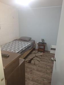 a small bedroom with a bed and a wooden floor at Casa agustina 2 in Valdivia