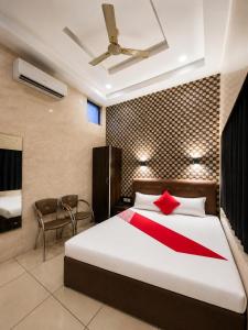 a bedroom with a large bed with a red blanket at HOTEL MAX - In Budget & Comfortable Rooms - For Corporates, Couples, Families Near HMV, DAV, Grain Market, Workshop Chowk in Jalandhar