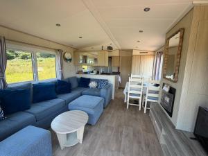 a living room with a blue couch and a table at Beachcomber's Paradise in Castlegregory +26 photos