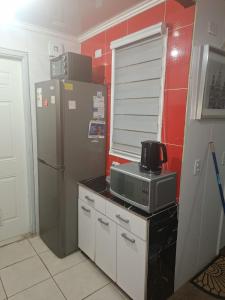 a kitchen with a refrigerator and a microwave on a counter at Casa agustina 2 in Valdivia