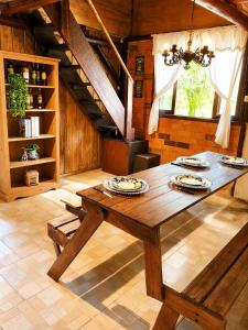 a dining room with a wooden table with plates on it at Cabana Liberdade in Rio dos Cedros