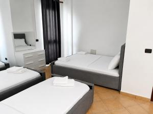 a room with two beds and a mirror at Hotel Gjakova-Shëngjin in Shëngjin