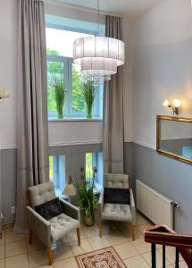 a living room with two chairs and a chandelier at Hotel Natura Centrum Zdrowia in Duszniki Zdrój +15 photos