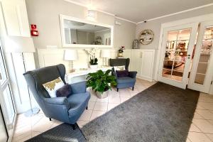 a living room with two chairs and a mirror at Hotel Natura Centrum Zdrowia in Duszniki Zdrój