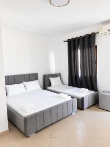 two beds in a room with black curtains at Hotel Gjakova-Shëngjin in Shëngjin