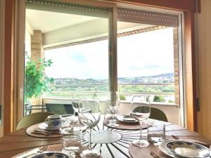 a table with glasses and plates and a large window at Douro View by Porto in Valbom