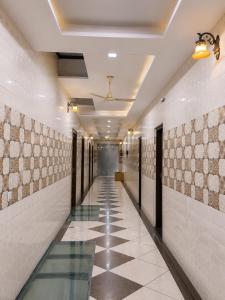 a hallway in a building with a tile floor at HOTEL MAX - In Budget & Comfortable Rooms - For Corporates, Couples, Families Near HMV, DAV, Grain Market, Workshop Chowk in Jalandhar