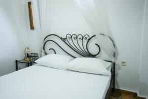 a white bed with white pillows in a room at Efi Pool & View Alepochori i in Kato Alepochori +33 photos