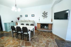 a dining room with a table and chairs and a tv at Efi Pool & View Alepochori i in Kato Alepochori