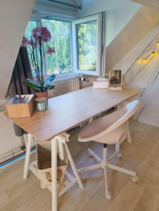 a wooden desk with a chair and a table at Quiet Riverside Apartment in Grosley-sur-Risle +11 photos