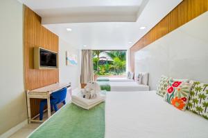 a room with a bed and a desk and a tv at Hotel Praia do Sol in Ilhéus +53 photos