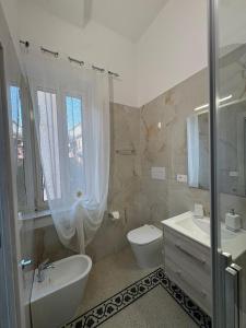 a white bathroom with a sink and a toilet at Scilla Central Rooms in Scilla +25 photos