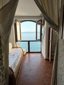 a bedroom with a bed and a view of the ocean at Marea Chianalea in Scilla