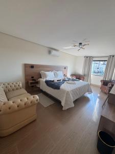 a bedroom with a bed and a couch at Le Bonne Ville Hotel in Campos do Jordão