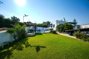 a large yard with green grass and white buildings at Efi Pool & View Alepochori i in Kato Alepochori