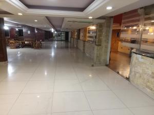 a hallway of a building with a large white tile floor at Hotel Bouery in An Nā‘ūrah +24 photos