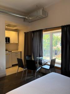 a room with a table and chairs and a kitchen at Dragon Gate Inn in Toronto